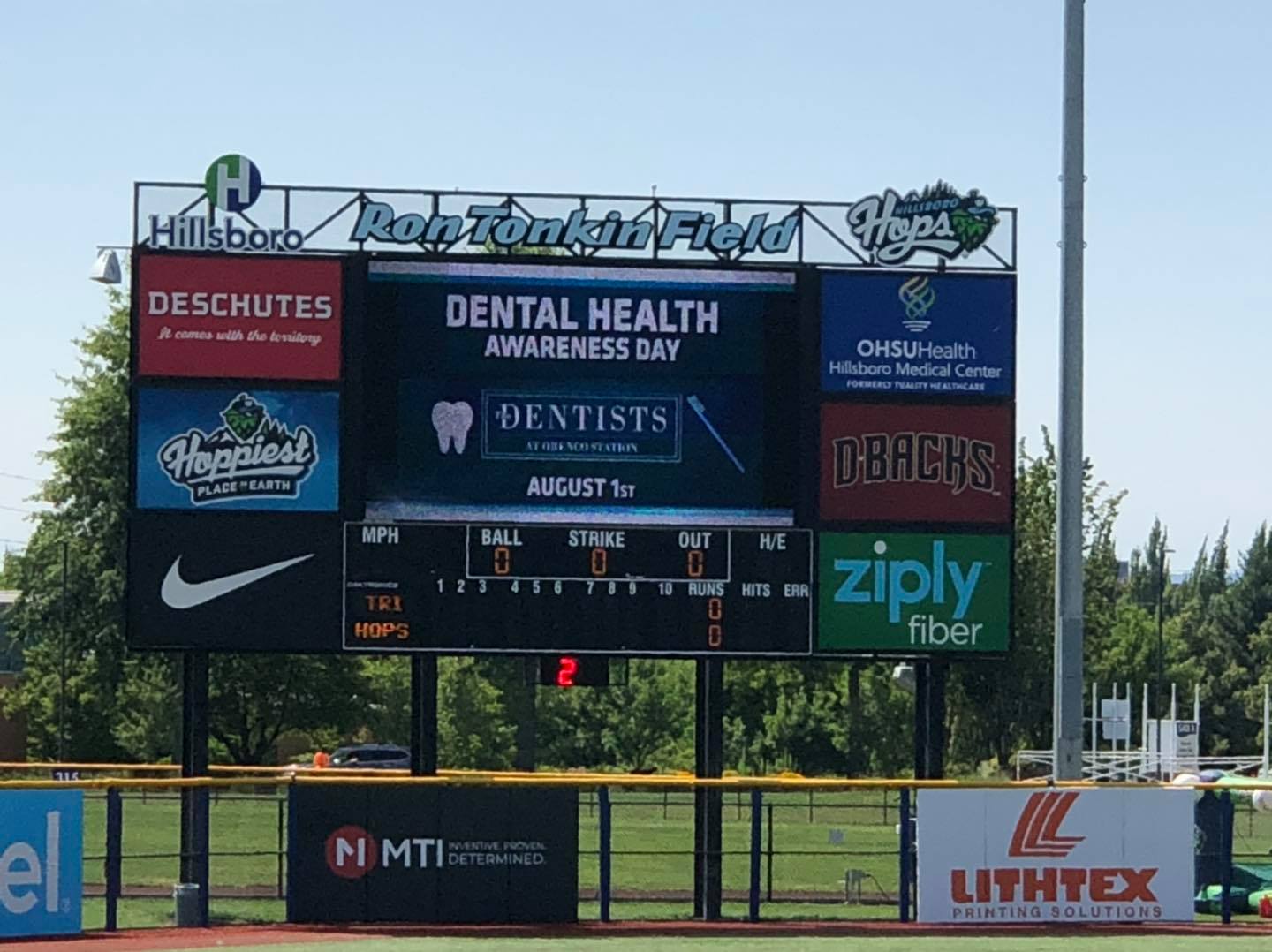 Baseball jumbo tron showing message from The Dentists at Orenco Station that reads Dental Health Awareness Day August 1