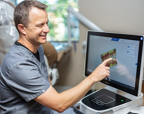 Dentist pointing to computer monitor with digital model of teeth