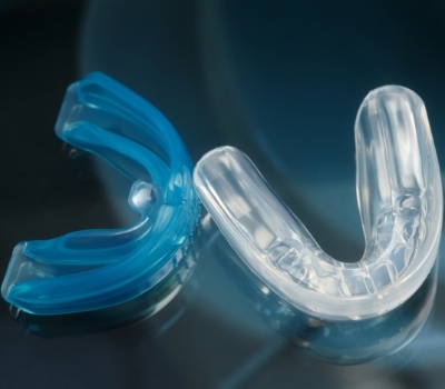 Blue mouthguard next to clear mouthguard