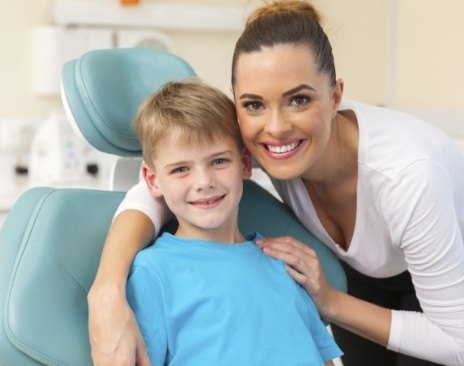 Mother hugging her son in dental chair