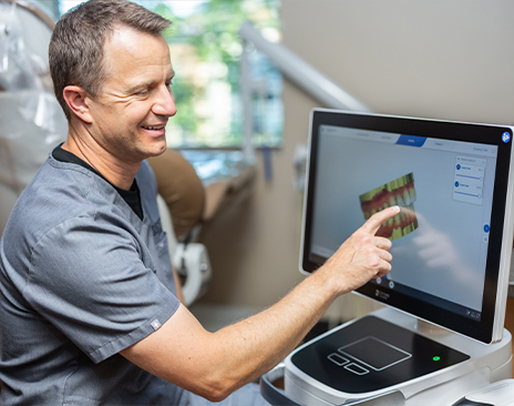 Dentist showing a patient a screen with digital models of teeth