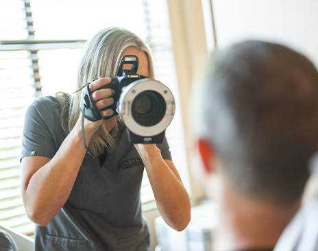 Dentist taking a photo of a patient with a large camera