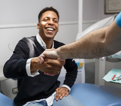 Male dental patient shaking dentist’s hand