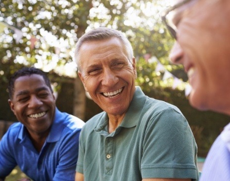 Three men laughing together outdoors