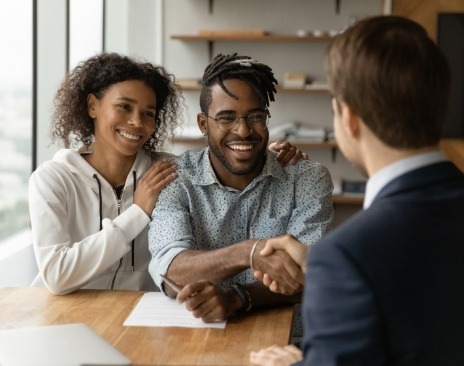 Man shaking hands with person across table