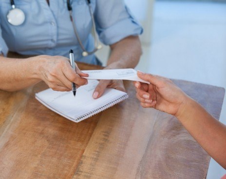 Person handing a check to person across table