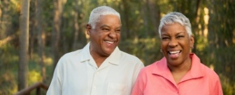 Older man and woman walking through forest