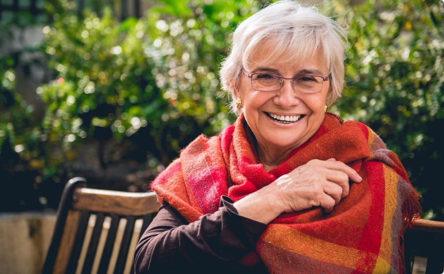 Senior woman in shawl smiling outdoors with dentures in Hillsboro