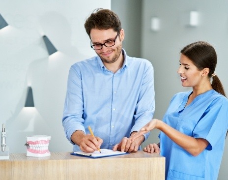 Dental team member showing a clipboard to a patient