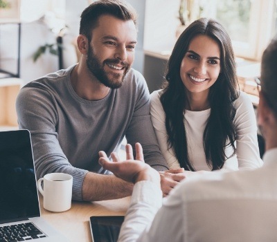 Man and woman talking to person sitting across table