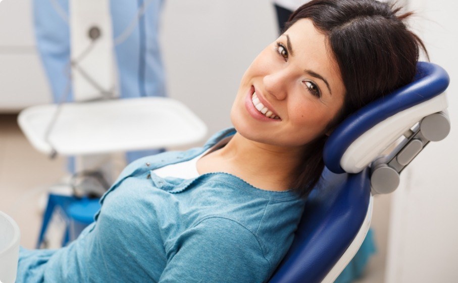 Smiling woman leaning back in dental chair