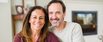 Smiling man and woman in their living room