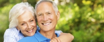 Smiling senior man and woman hugging outdoors