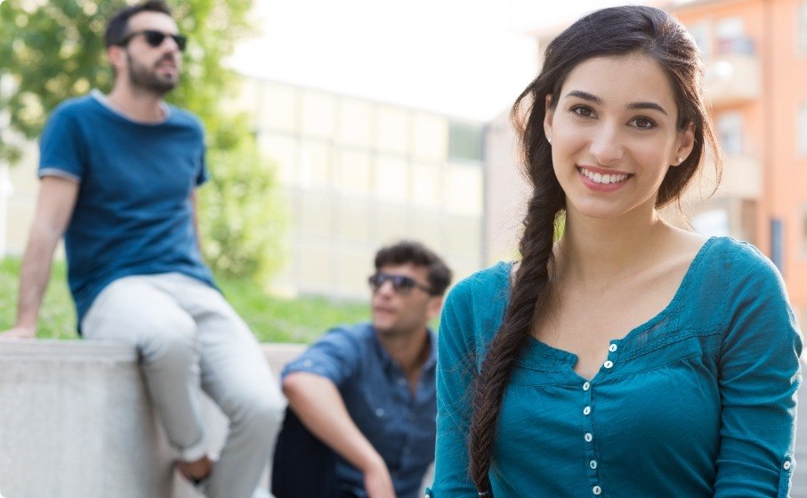 Woman smiling in courtyard with Sure Smile clear aligners in Hillsboro