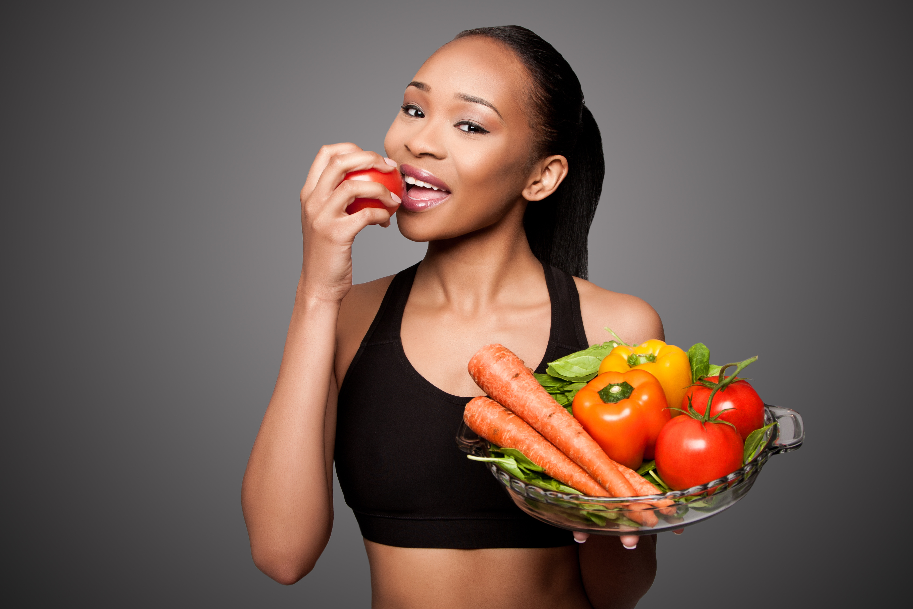happy-healthy-black-asian-woman-eating-vegetables-dentists-at-orenco-blog