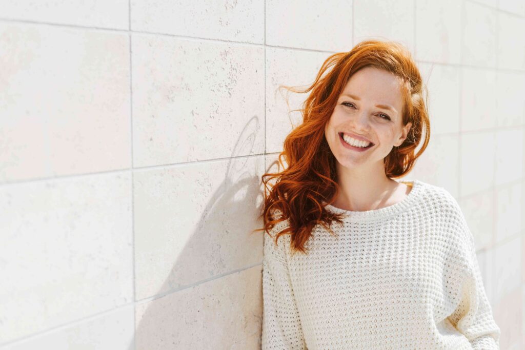 Woman smiling against a wall